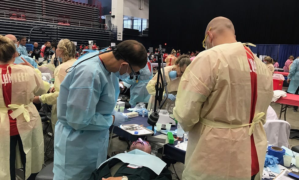 Dentists treating patients at community dental care event