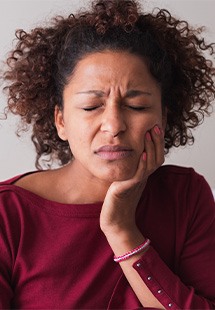 Woman with toothache sitting on couch at home