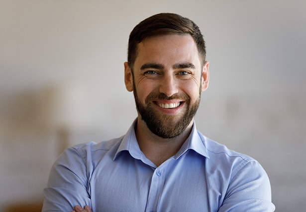 Bearded man with a button-up shirt smiling