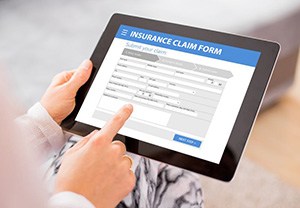 Person filling out insurance claim form on tablet