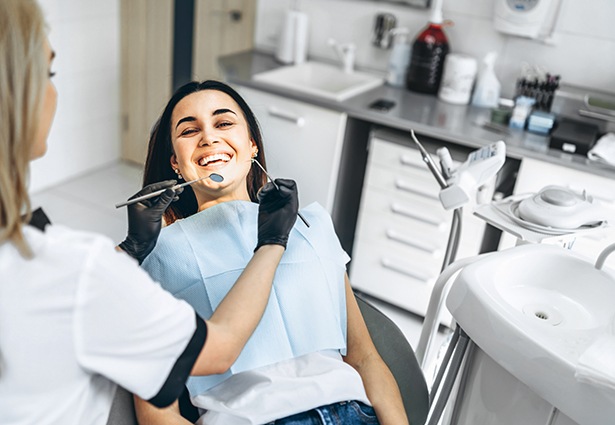 Dentist in Pittsburgh evaluating a patient's smile for cosmetic bonding candidacy 