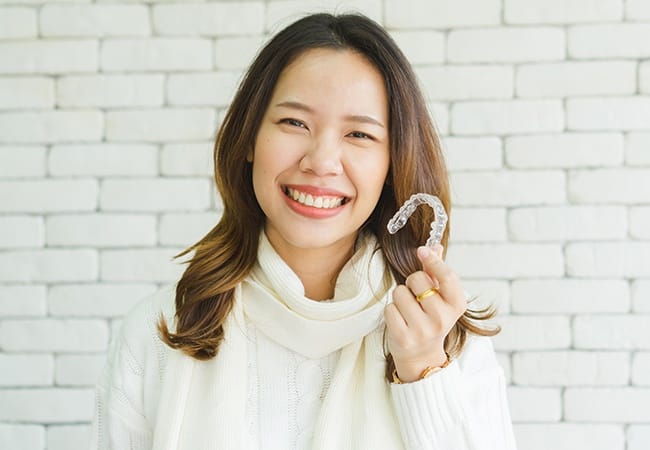 Patient holding up an Invisalign tray