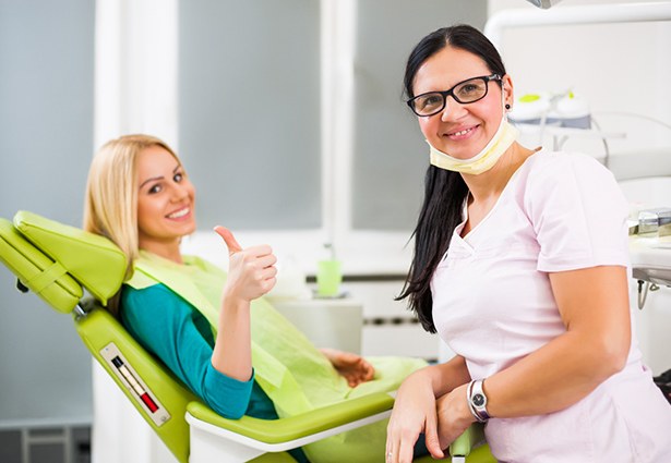 Happy dental patient at appointment to use her dental insurance policy