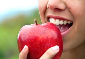 Closeup of patient with dental implants in Pittsburgh eating an apple