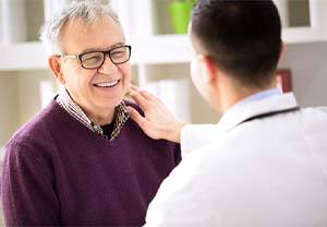 Healthy older man with dental implants in Pittsburgh smiling at doctor