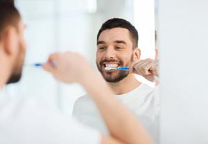 man brushing his teeth 