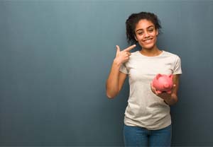 woman with piggy bank pointing to her smile