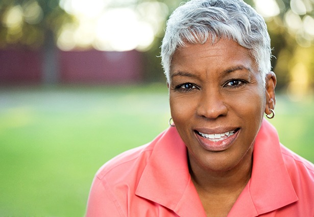 Closeup of smiling woman wearing coral shirt