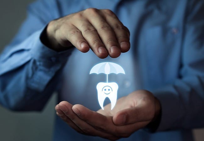 Hands holding an animated tooth under an umbrella