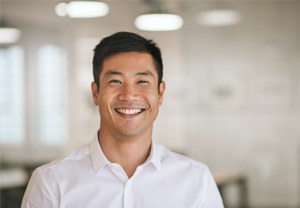 Man in white button-up shirt smiling in office