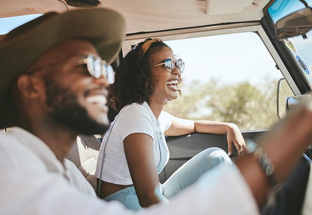 Friends on road trip smiling in car