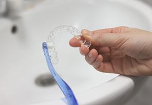 Patient cleaning clear aligner with toothbrush