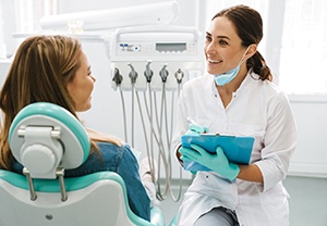 Smiling dentist taking notes on clipboard