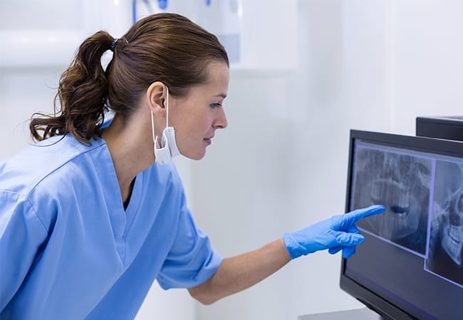 Dentist examining digital x-rays