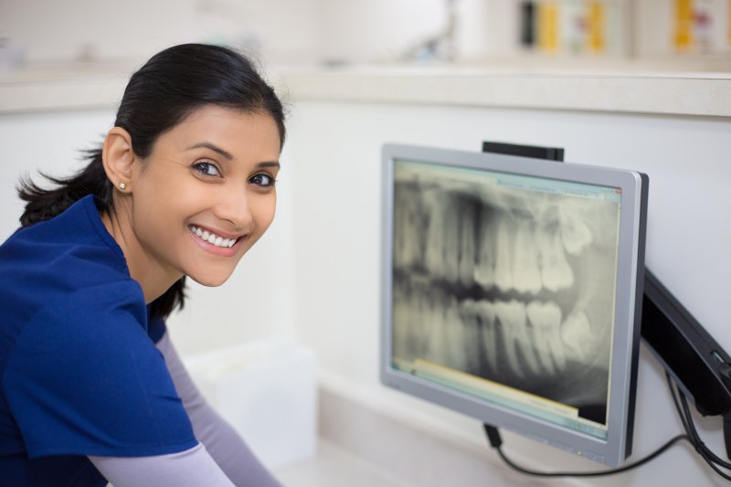 Dentist examining X-ray for TMJ therapy in Pittsburgh