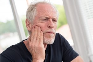 Portrait of mature man with jaw pain at home