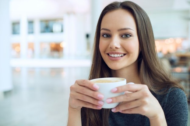 person with hands wrapped around coffee mug