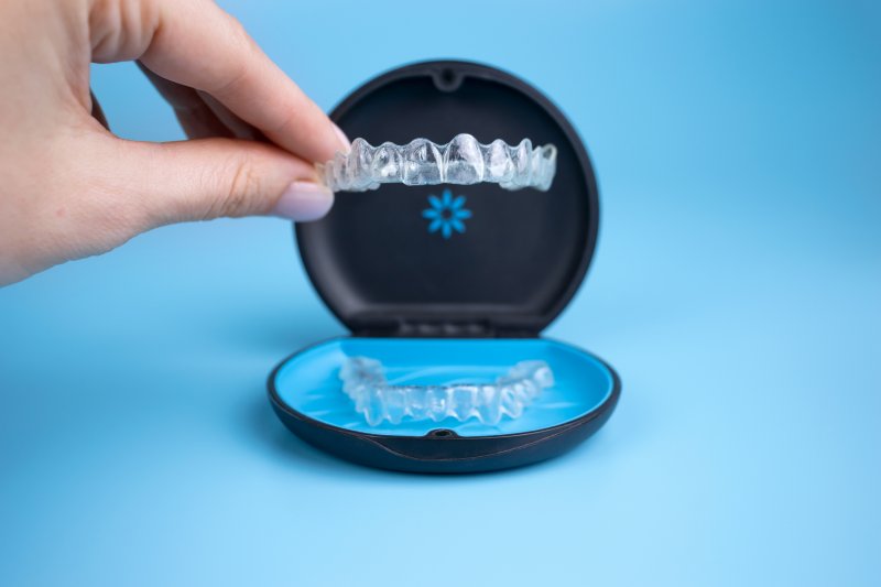 person inserting Invisalign aligner into protective case