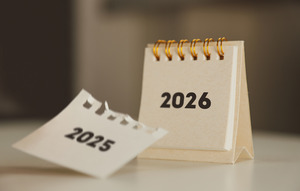 Tearing off calendar page for 2025 to show page for 2026
