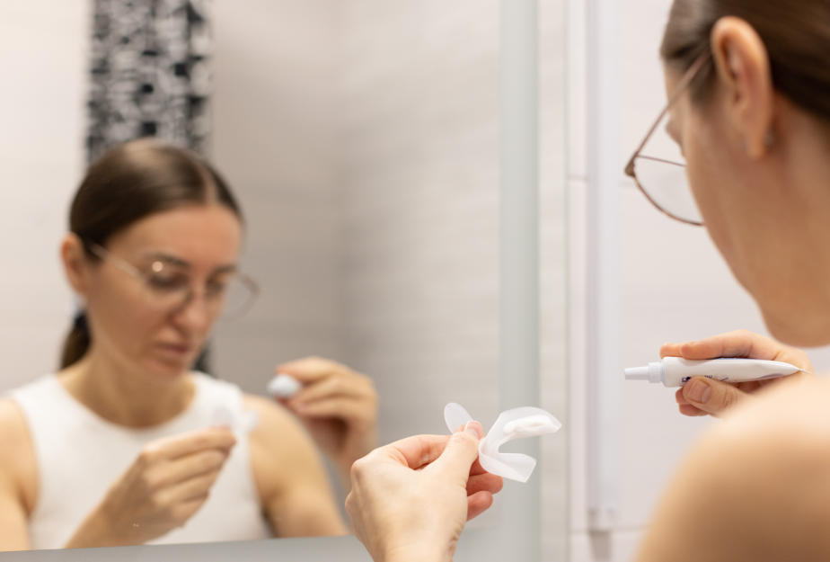 Woman applying DIY teeth whitening tray