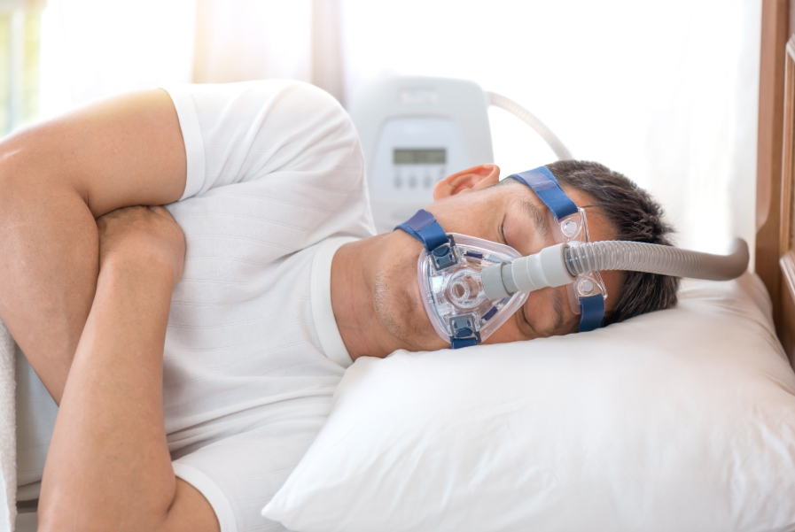 Man wearing CPAP sleeping with arms folded