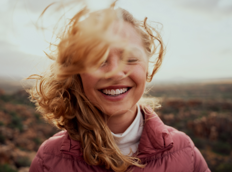 Woman smiling with hair blowing in the wind